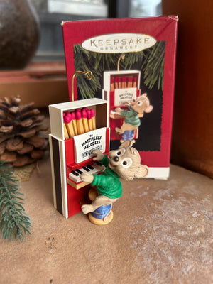 A Hallmark Keepsake ornament featuring a cartoon mouse playing a piano made from a matchbox, adorable vintage collectible