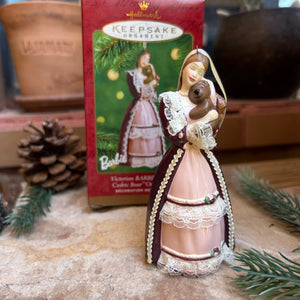 Decorative Barbie and favorite lil bear Christmas ornament on a stone surface with a blurred background