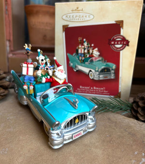 Decorative toy car with Santa Claus figure and Christmas decorations, featuring a Hallmark Keepsake ornament packaging.
