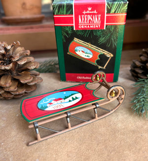 Christmas sled ornament with '1991' design in front of a Hallmark Keepsake Ornament box.