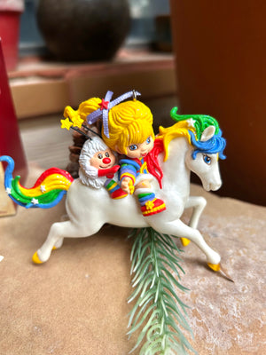 Colorful figurine of a character riding a unicorn on a textured surface