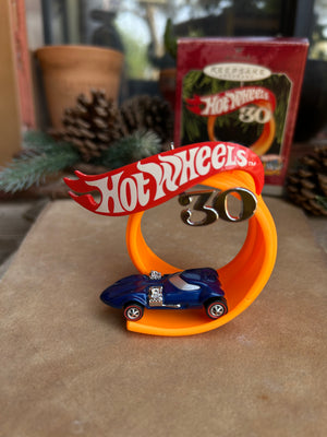 Hot Wheels bottle opener on a wall with a box of cookies in the background