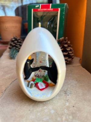 Decorative keepsake ornament with penguin and Christmas Tree scene in a three window oval egg design 