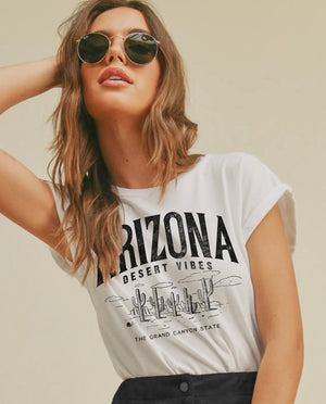 Woman wearing a white t-shirt with 'Arizona Desert Vibes' features roll up short sleeves  