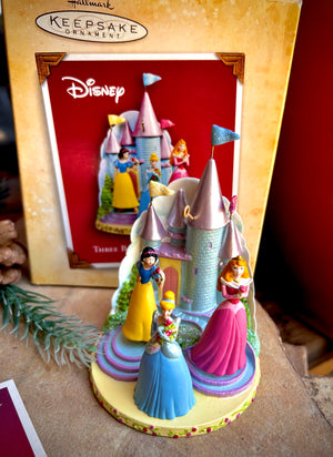 Disney princesses Cinderella, Snow White and Sleeping Beauty keepsake ornament standing in front of a castle