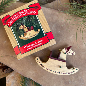 A wooden rocking horse Christmas ornament from Hallmark, placed next to its packaging which has 'old-fashioned Christmas collection' written on it.