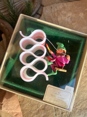 A vintage 1982 Hallmark Keepsake ornament featuring an elf with a paintbrush over ribbon candy, packaged in its original box.