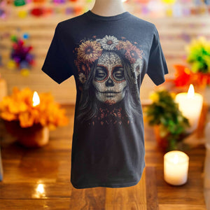 Dia de los muertos or day of the dead Black t-shirt with a skull design on a mannequin against a festive background with candles and flowers.